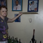 Ruth Christie, a resident a LES II, lifts up a frame she hung to hide a hole in her wall. (Photo by Rachel Wise)