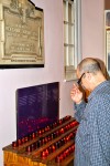 Louie Gonzalez, who lost his sister, Aida Rosario on 9/11,, lights a candle for her at Trinity Church near ground zero. Photo by Charles Li