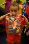 Emanuel Rivera, 5, of the Mott Haven Academy Charter School shows off a goodie bag of school supplies. The back to school event provided low-income and foster care students with necessities for their first year in school. Photo by Timothy Weisberg.