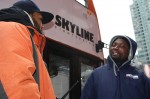 Tour bus ticket vendor Amara Fofana (right) talks to supervisor Johnny Morales (left) outside a tour bus in Times Square as temperatures start to drop. Photo by Rajeev Dhir.