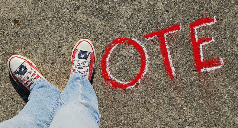 Pavement with sneakers and Vote written in chalk