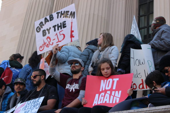 A group of protesters sit outside the National Archives at March for Our Lives in Washington, D.C.